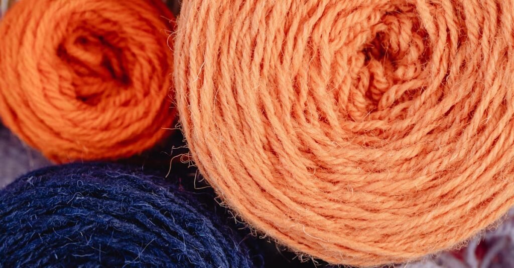 pexels-photo-6634268-6634268-1 Top view of vibrant wool yarn balls arranged on a loom, ideal for crafting and knitting projects.
